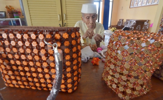 Agus Mulyno yang sudah berumur 87 tahun sedang mengerjakan berbagai macam jenis kerajinan tangan berbahan manik-manik. 